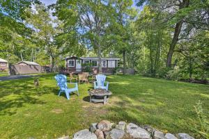 North Hero的住宿－Cozy Lake Champlain Cottage with Private Beach!，一个带两把蓝色椅子和一个火坑的院子