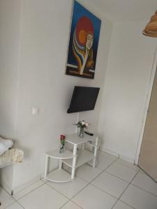 Habitación blanca con mesa y pintura en la pared en studio sympa, en Port-Louis