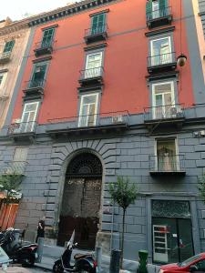 un edificio rosso con moto parcheggiate di fronte di B&B Dei Decumani a Napoli