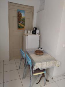 a kitchen with a table and chairs and a refrigerator at studio sympa in Port-Louis