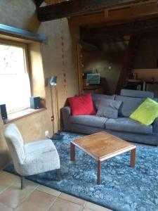 uma sala de estar com um sofá e uma mesa de centro em Chaleureuse maisonnette em Lopérec