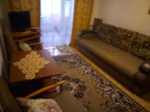 een woonkamer met een bank en een tafel bij Затишна 2 кімнатна квартира Трускавець in Truskavets