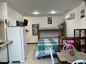 uma pequena cozinha com um frigorífico e uma cama em Flat Rosebahia em Morro de São Paulo
