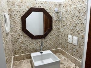 uma casa de banho com um lavatório e um espelho na parede em Flat Rosebahia em Morro de São Paulo