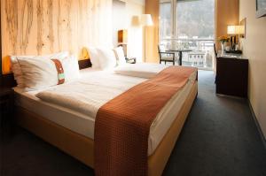 a large bed in a hotel room with a window at Holiday Inn - Salzburg City by IHG in Salzburg +113 photos