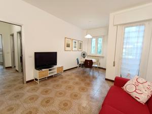 ein Wohnzimmer mit einem roten Sofa und einem Flachbild-TV in der Unterkunft Maison de Carmen in Abbadia Lariana