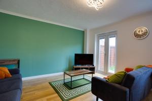 スウィンドンにあるST AUSTELL - Spacious Home, High Speed Wi-Fi, Free Parking, Gardenの青いソファ2脚とテレビのあるリビングルーム