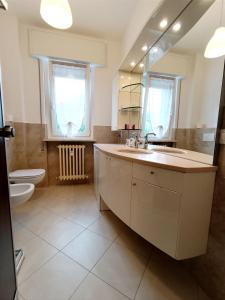 ein Badezimmer mit einem Waschbecken, einem WC und einem Spiegel in der Unterkunft Maison de Carmen in Abbadia Lariana