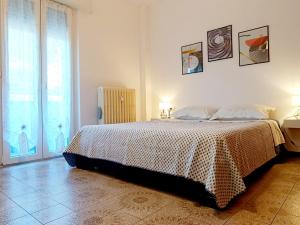 ein weißes Schlafzimmer mit einem Bett und einem Fenster in der Unterkunft Maison de Carmen in Abbadia Lariana