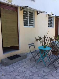 una mesa azul y sillas frente a una casa en studio sympa, en Port-Louis