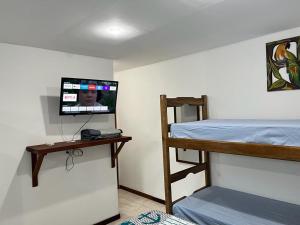 モロ・デ・サンパウロにあるFlat Rosebahiaのベッドルーム1室(二段ベッド1台、壁にテレビ付)