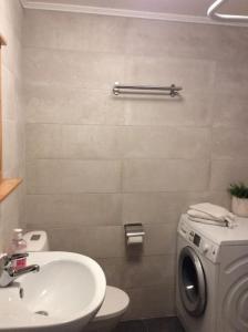 a bathroom with a sink and a washing machine at Apartment , Øygarden, Bergen in Torsteinsvik
