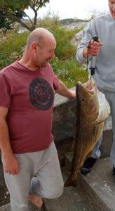 a man is holding a fish in its mouth at Apartment , Øygarden, Bergen in Torsteinsvik