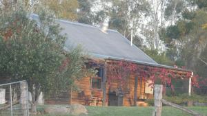 a log cabin with a black roof at Candlebark Retreat in Beechworth