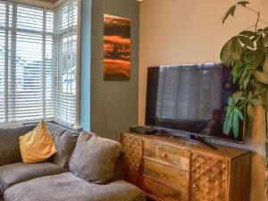 a living room with a couch and a flat screen tv at Nalas Cottage in Skegness