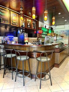 a bar in a restaurant with four stools at Sun Island in Puerto Villamil