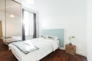 1 dormitorio blanco con 1 cama grande y espejo en 2 Bdrs Promenade des Anglais - AC, en Niza