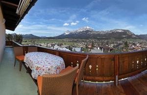 einen Balkon mit einem Tisch, Stühlen und Bergen in der Unterkunft Appartements Kaiserblick in Sankt Johann in Tirol