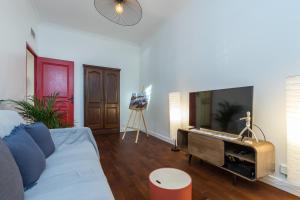 a living room with a couch and a flat screen tv at LE 323 PROM - 2 chambres - AC - PARKING - tram et supermarché proches - Front de mer in Nice