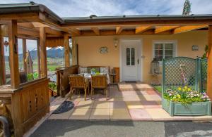 eine Außenterrasse mit einer hölzernen Pergola in der Unterkunft Appartements Kaiserblick in Sankt Johann in Tirol