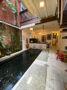 an indoor swimming pool in a house with a kitchen at Rumah Warisan Penang in George Town