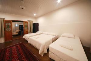 a hotel room with two beds and a red rug at Rumah Warisan Penang in George Town