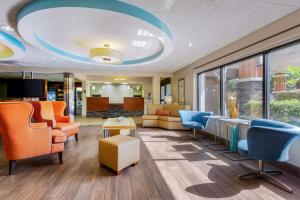 an office lobby with orange chairs and blue chairs at Best Western Plus Wilmington / Wrightsville Beach in Wilmington