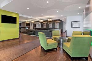 sala de estar con sillas verdes y sofá en Best Western Plus East Side en Saskatoon