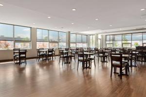 a large room with tables and chairs and windows at Best Western Plus East Side in Saskatoon