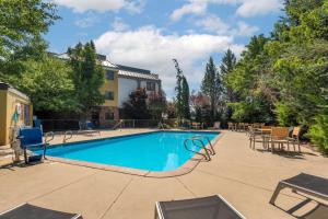 una piscina en un patio con sillas y mesas en Best Western Plus Olympic Inn, en Klamath Falls