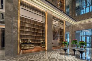 a library with large bookshelves and tables at Radisson Blu Hotel & Spa, Nashik in Nashik