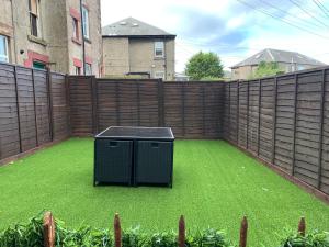 a backyard with a fence and a green lawn at Nelson st ALVA in Largs