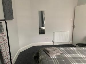 a bedroom with a bed with a mirror and a window at Nelson st ALVA in Largs