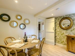 uma sala de jantar com mesa, cadeiras e espelhos em The Lodge - Uk32622 em Swannington