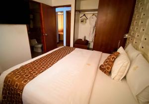 ein Schlafzimmer mit einem großen weißen Bett mit weißen Kissen in der Unterkunft Inkari Apart Hotel in Lima