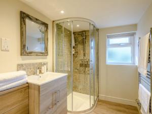 uma casa de banho com um chuveiro, um lavatório e um espelho. em The Lodge - Uk32622 em Swannington