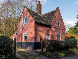 uma velha casa vermelha com um telhado preto em The Lodge - Uk32622 em Swannington