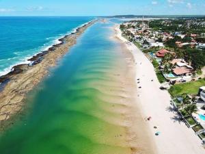 uma vista aérea de uma praia com casas e o oceano em Iloa Residence Luxo na Barra de São Miguel