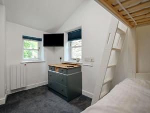 a bedroom with a bed and a desk and a bunk bed at Holly Cottage in Kettlewell
