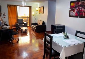 ein Wohnzimmer mit einem weißen Tisch und Stühlen in der Unterkunft Inkari Apart Hotel in Lima