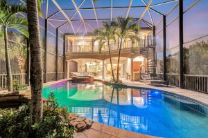una piscina cubierta con una casa grande con un edificio en Villa De La Mar at Casey Key, en Nokomis