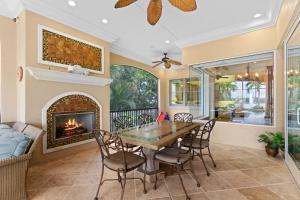 Un comedor con chimenea y una mesa y sillas. en Villa De La Mar at Casey Key, en Nokomis