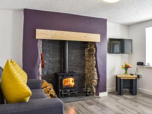 a living room with a fireplace and a couch at Chuckle Cottage in Braunton
