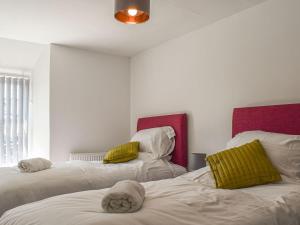 a room with two beds with towels on them at Chuckle Cottage in Braunton