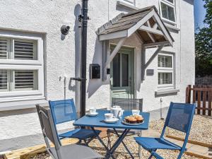 a blue table and chairs in front of a house at Chuckle Cottage in Braunton