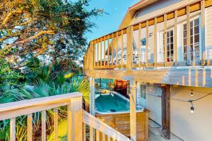 a deck with a hot tub on the side of a house at Island Palms in St. George Island
