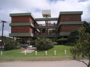 un gran edificio de ladrillo con un balcón en la parte superior. en VILLA GESELL Departamento Frente al Mar en Villa Gesell
