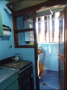 een kleine keuken met een fornuis en een raam bij VILLA GESELL Departamento Frente al Mar in Villa Gesell
