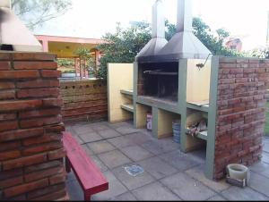 un horno de pizza en un patio junto a una pared de ladrillo en VILLA GESELL Departamento Frente al Mar en Villa Gesell