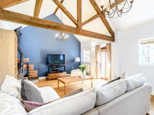 a living room with a white couch and a tv at Low Barn in Market Bosworth